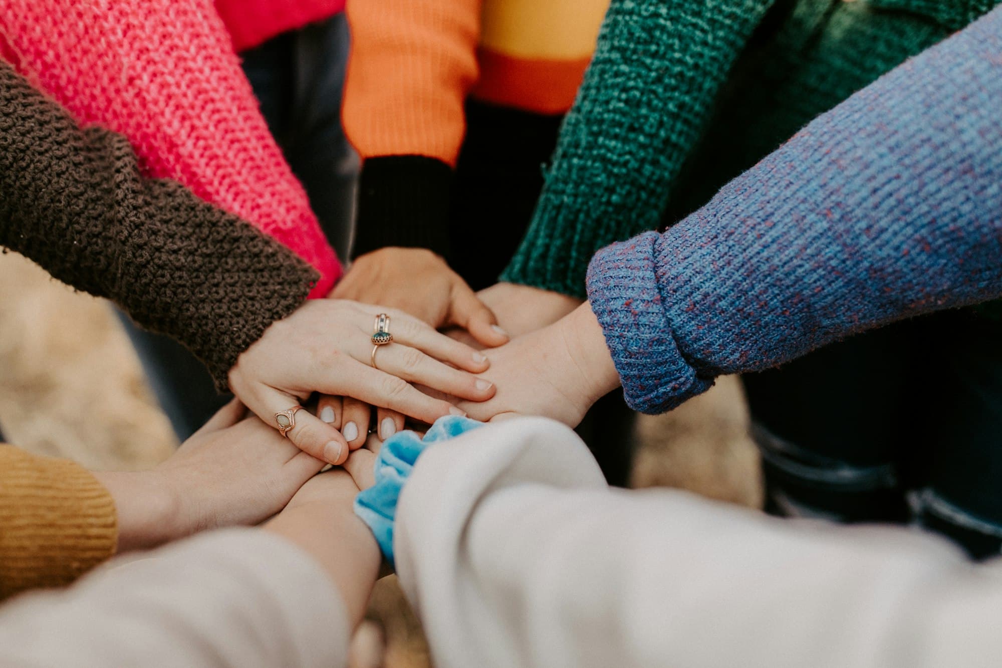 A diverse group of people stacking their hands together in support